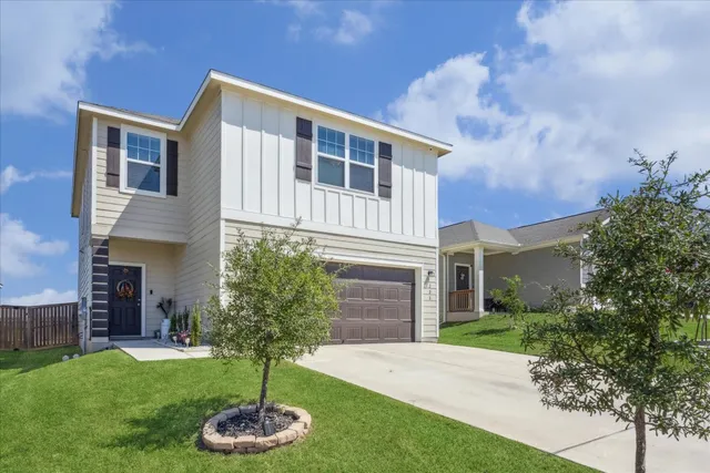 a front view of a house with a yard and garage