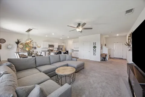 a living room with furniture kitchen and a chandelier
