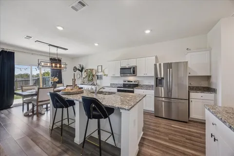 a kitchen with refrigerator a stove and wooden floor