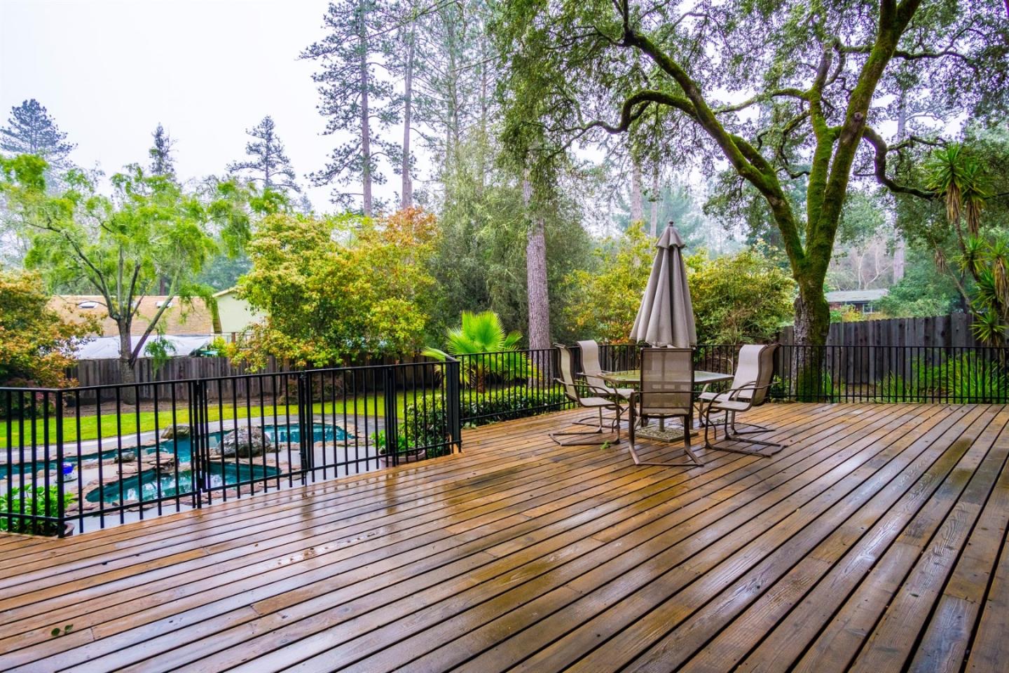 661 Sugar Pine Road Scotts Valley, CA 95066 - Photo 9 of 40 a view of a roof deck with table and chairs a barbeque with wooden floor and fence