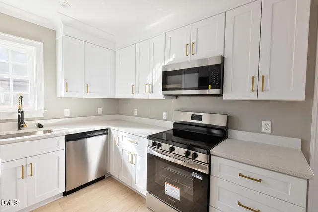 a kitchen with white cabinets and white appliances