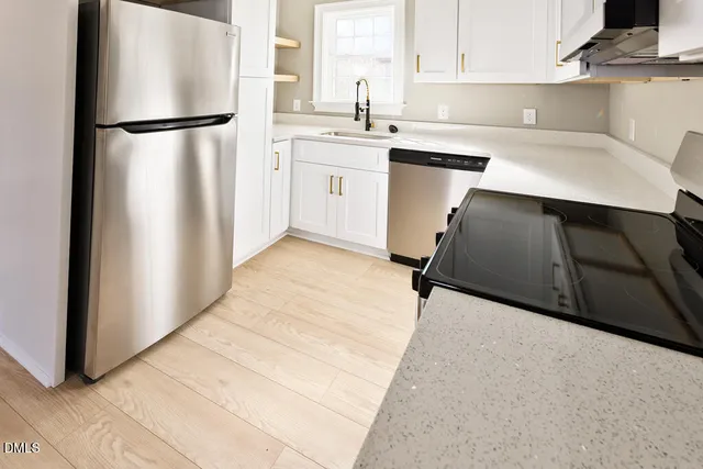a kitchen with a refrigerator sink and cabinets