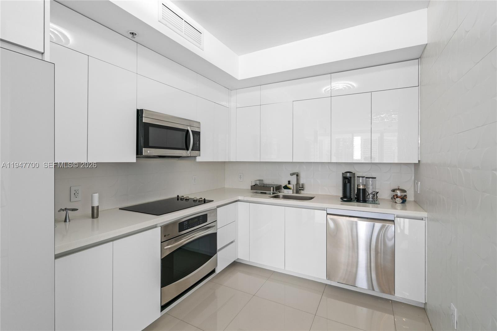 90 Southwest 3rd Street, Unit 2204 Miami, FL 33130 - Photo 11 of 51 a kitchen with white cabinets stainless steel appliances and sink