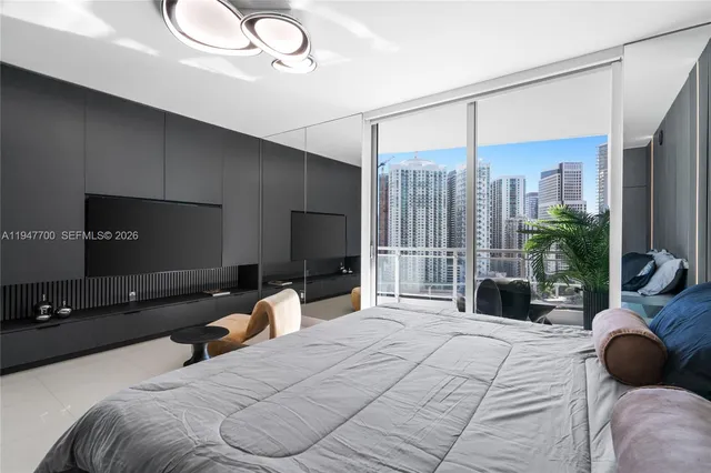 a bedroom with a bed couch and large window