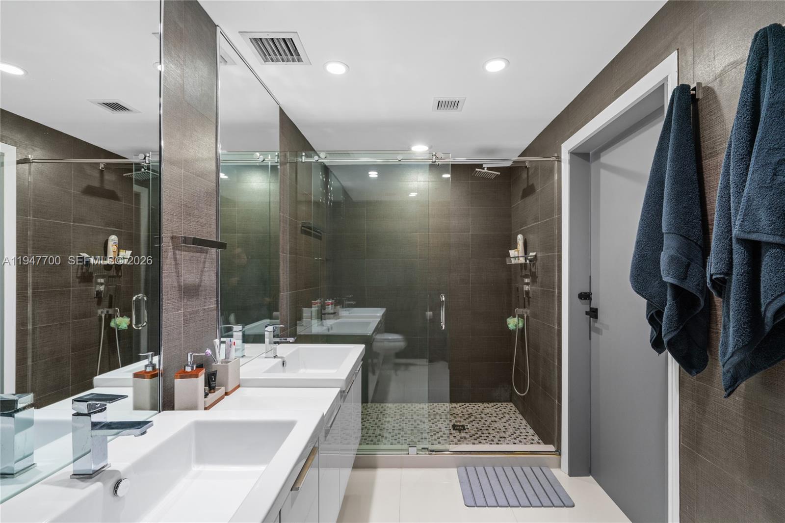 90 Southwest 3rd Street, Unit 2204 Miami, FL 33130 - Photo 23 of 51 a bathroom with a tub shower sink vanity and a mirror