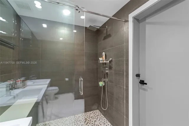 a bathroom with a sink a toilet and shower