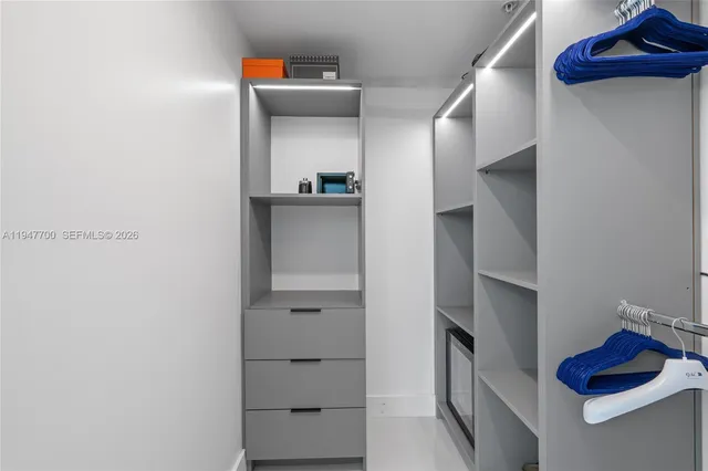 a view of walk in closet with clothes and shoes