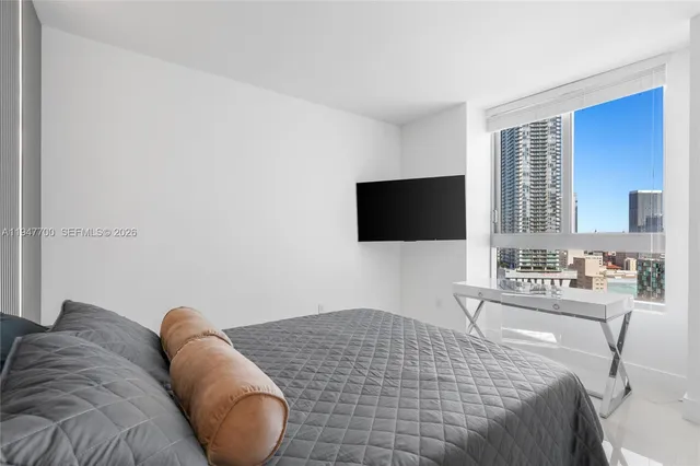 a bedroom with a bed and a flat screen tv