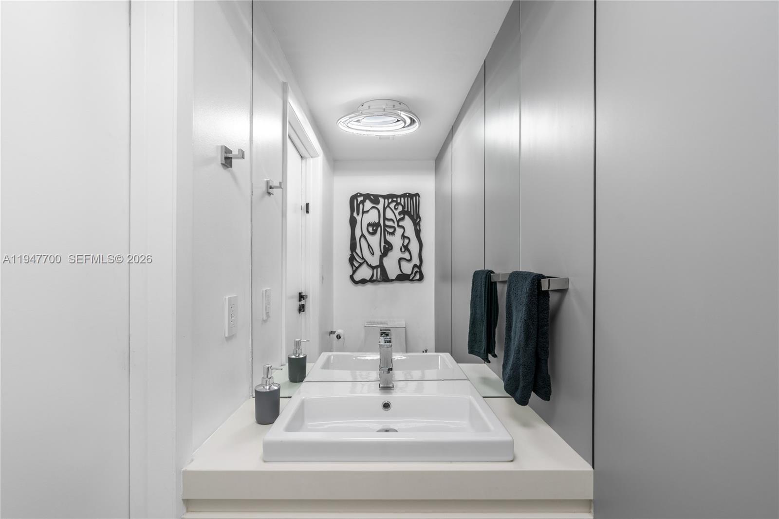 90 Southwest 3rd Street, Unit 2204 Miami, FL 33130 - Photo 34 of 51 a bathroom with a sink and a mirror