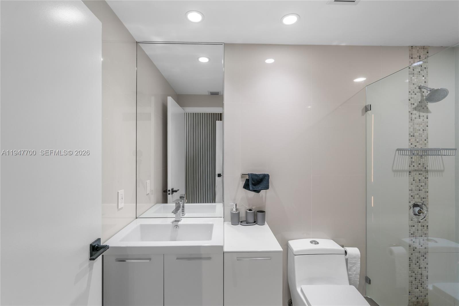 90 Southwest 3rd Street, Unit 2204 Miami, FL 33130 - Photo 35 of 51 a bathroom with a toilet sink and mirror