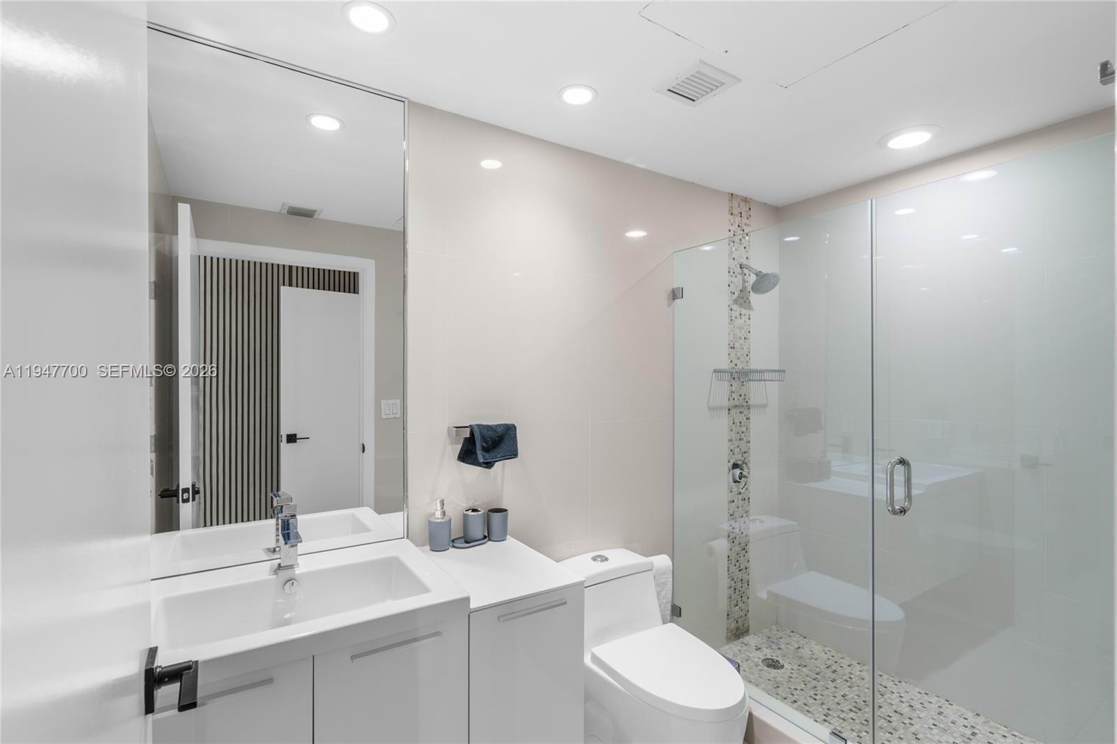 90 Southwest 3rd Street, Unit 2204 Miami, FL 33130 - Photo 36 of 51 a bathroom with a toilet a sink a mirror and vanity