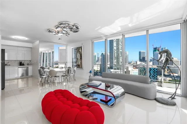 a living room with furniture a chandelier and a large window
