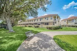 a view of a big house with a big yard and large trees