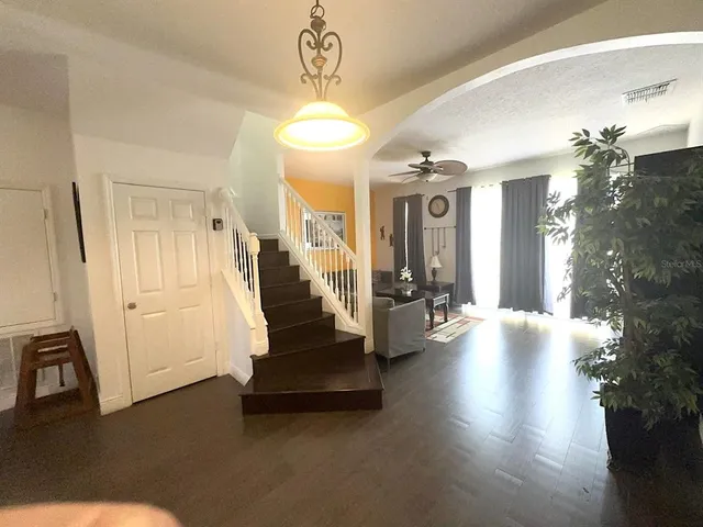 a view of a livingroom with a furniture wooden floor and a chandelier