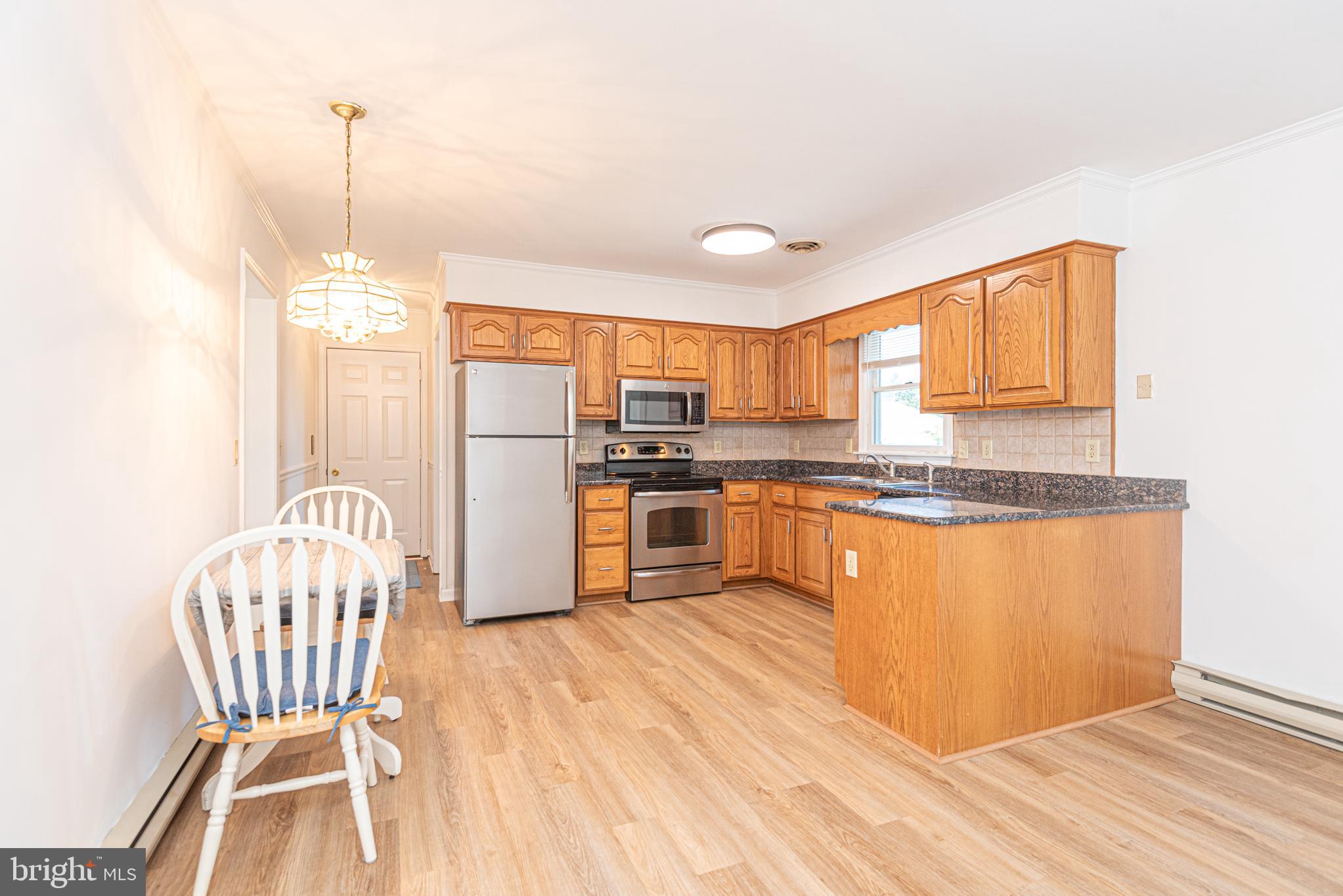 38241 Marlington Road Ocean View, DE 19970 - Photo 11 of 40 a kitchen with granite countertop a refrigerator a stove a sink dishwasher with a dining table and chairs