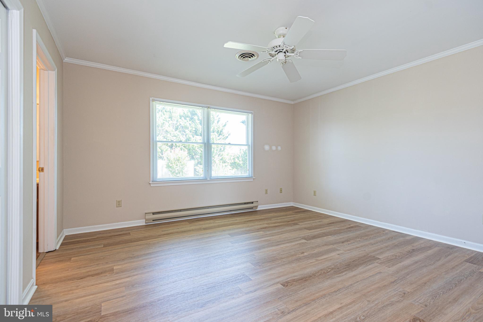 38241 Marlington Road Ocean View, DE 19970 - Photo 14 of 40 an empty room with wooden floor chandelier fan and windows