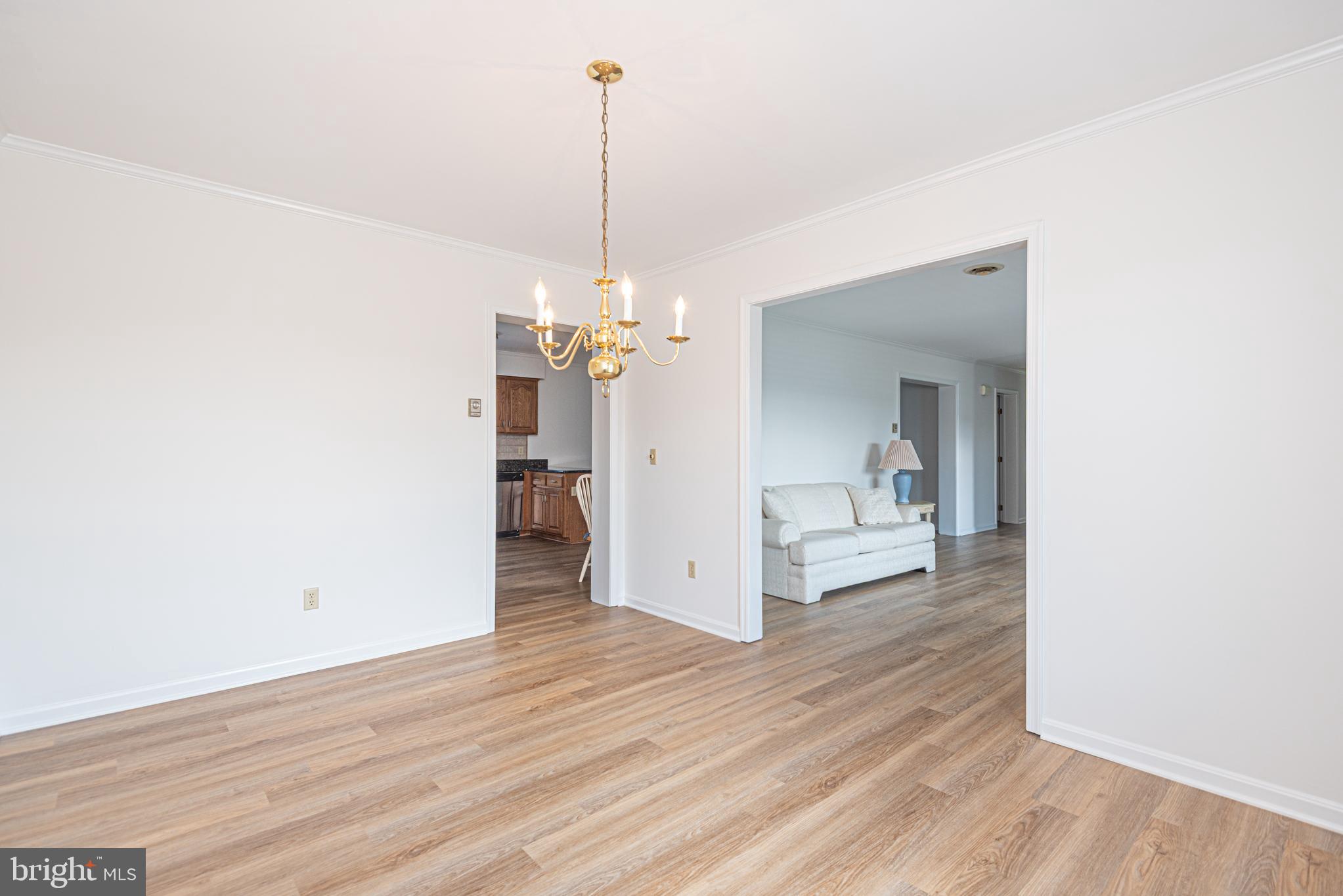 38241 Marlington Road Ocean View, DE 19970 - Photo 10 of 40 a view of a room with wooden floor and a chandelier