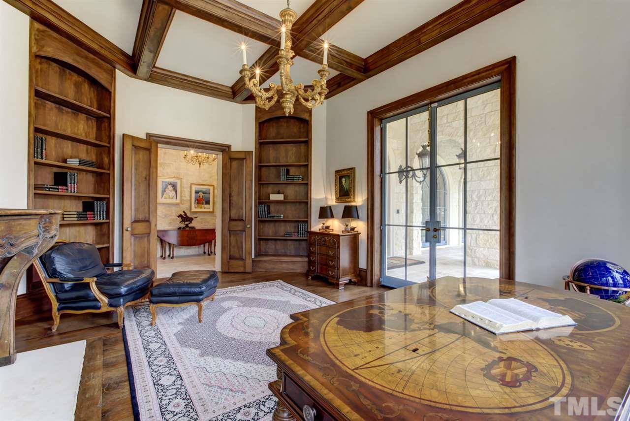648 Tant Road Spring Hope, NC 27882 - Photo 14 of 30 Double doors open into the study that includes a coffered ceiling, wide-plank hardwood floors, built-in’s, and a stone fireplace with a special wooden mantle with beetles imported from France.