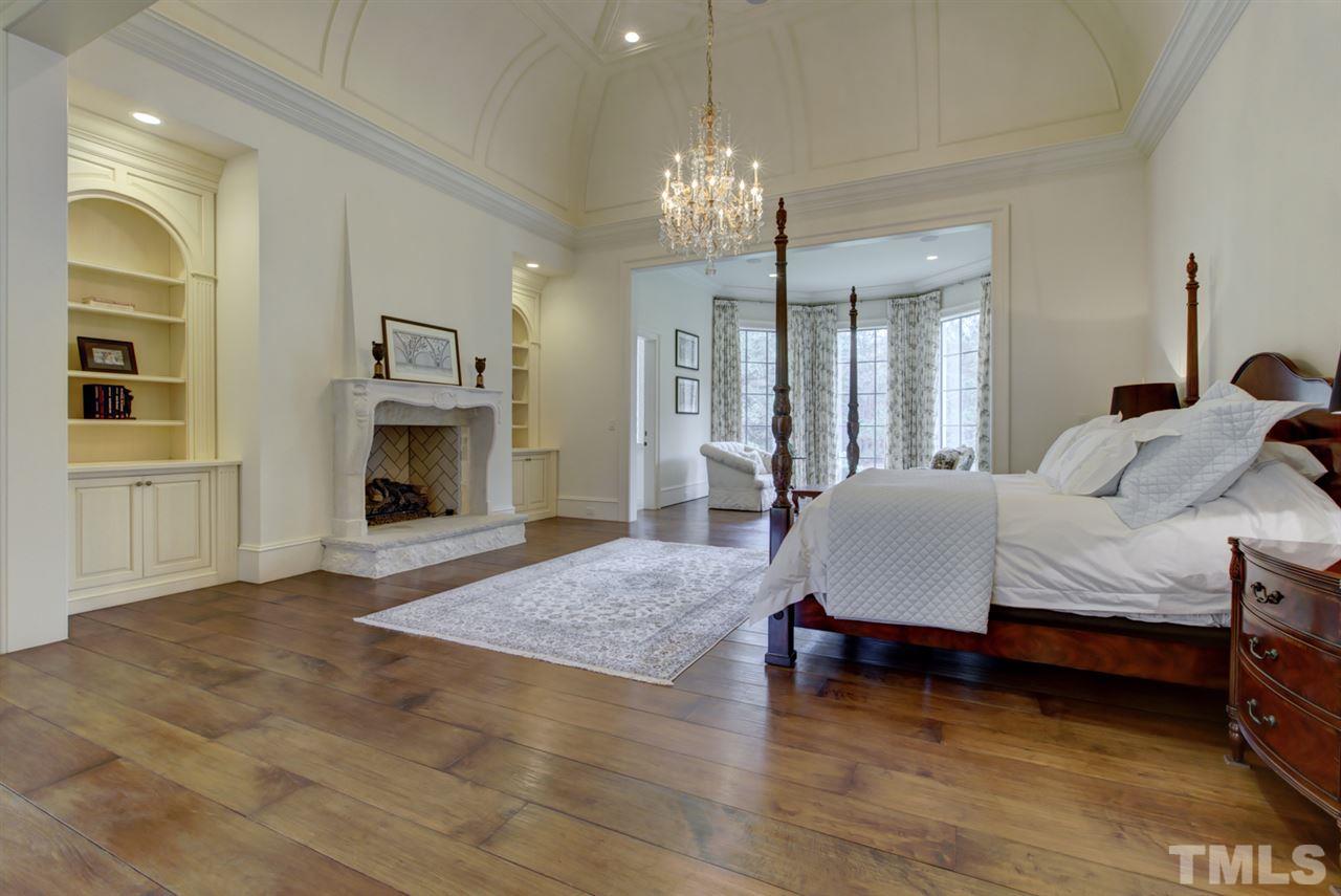 648 Tant Road Spring Hope, NC 27882 - Photo 15 of 30 The master suite has wide-plank hardwood floors, a sitting room with pond views, wet bar with refrigerator, unique trim ceiling, and a stone fireplace with side built-in’s.