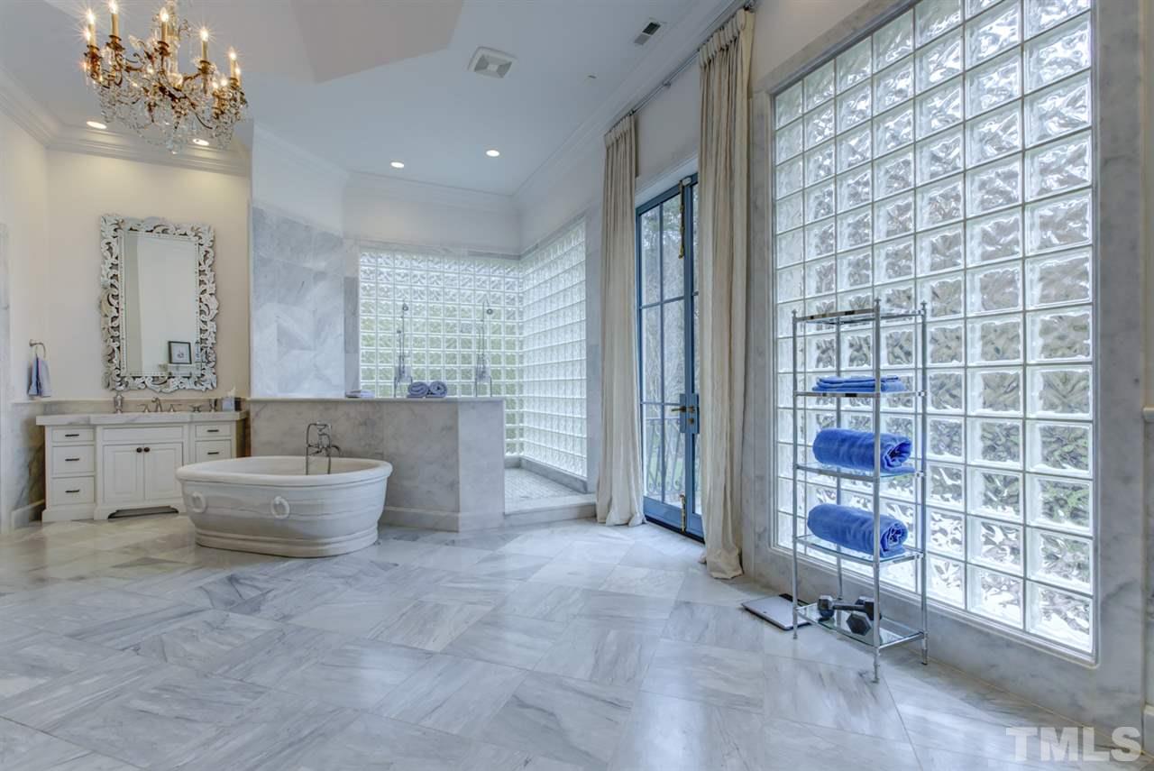 648 Tant Road Spring Hope, NC 27882 - Photo 16 of 30 The luxury master bath has two vanities, a $50K hand hewn Carrera marble stone tub with support beam imported from France, tiled walk-in shower, and a stone fireplace.