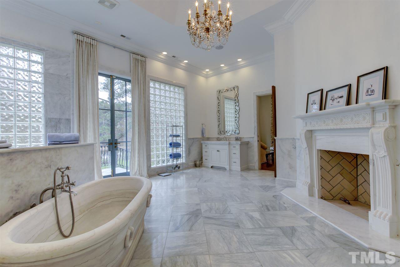 648 Tant Road Spring Hope, NC 27882 - Photo 17 of 30 The luxury master bath has two vanities, a $50K hand hewn Carrera marble stone tub with support beam imported from France, tiled walk-in shower, and a stone fireplace.