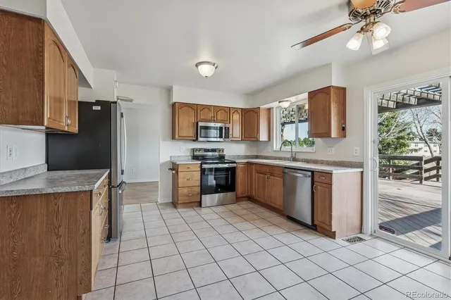 a kitchen with stainless steel appliances a sink counter space cabinets and a window