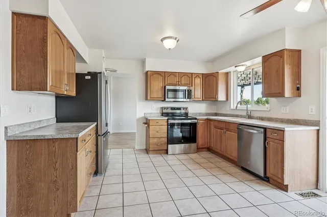 a kitchen with stainless steel appliances granite countertop a stove top oven a sink a counter top space and cabinets