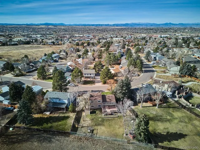 an aerial view of residential houses with outdoor space and ocean