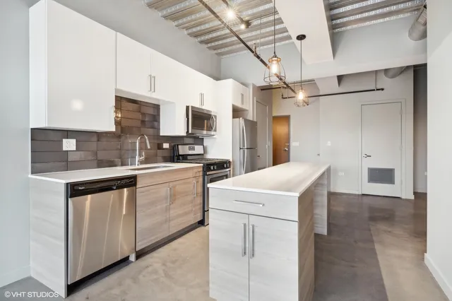 a kitchen with stainless steel appliances a refrigerator sink and cabinets
