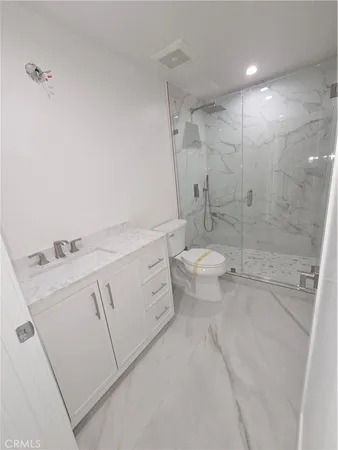 an empty room with wooden floor closet and windows