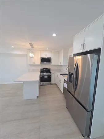a kitchen with stainless steel appliances a refrigerator sink and stove