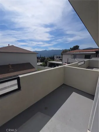 a view of balcony with two potted plants and large trees