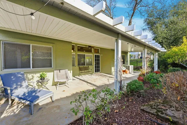 a view of a chair and table in backyard of the house