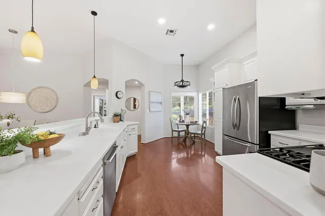 a kitchen with sink refrigerator and cabinets