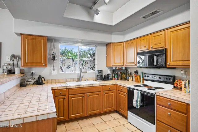 a kitchen with a sink a stove cabinets and a window
