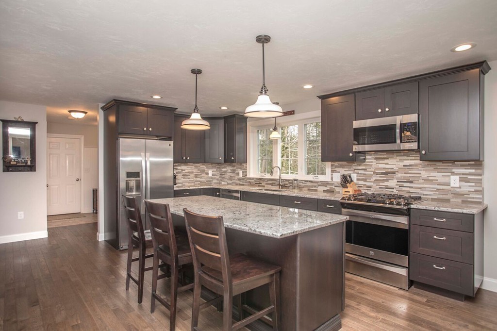 20 Strathmore Road East Bridgewater, MA 02333 - Photo 7 of 30 a kitchen with stainless steel appliances granite countertop a sink a stove a microwave a island with wooden floor and cabinets