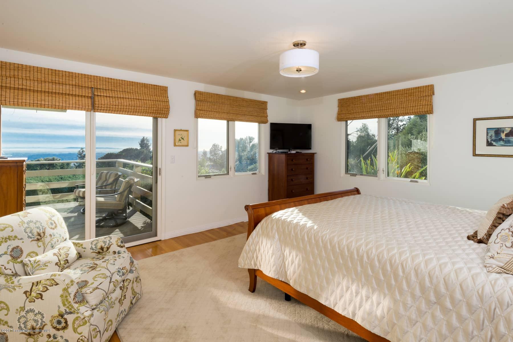3430 Ellington Villa Drive Altadena, CA 91001 - Photo 19 of 49 a bedroom with a large bed and a flat tv screen next to a window