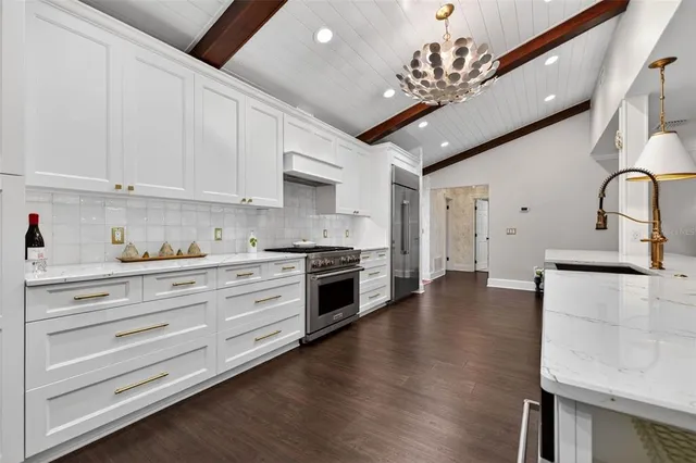 a kitchen with stainless steel appliances granite countertop a lot of counter space and wooden floors
