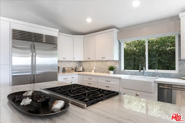 a kitchen with a stove a refrigerator and a window
