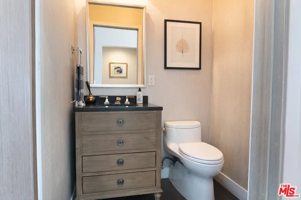 a bathroom with a toilet a sink and mirror
