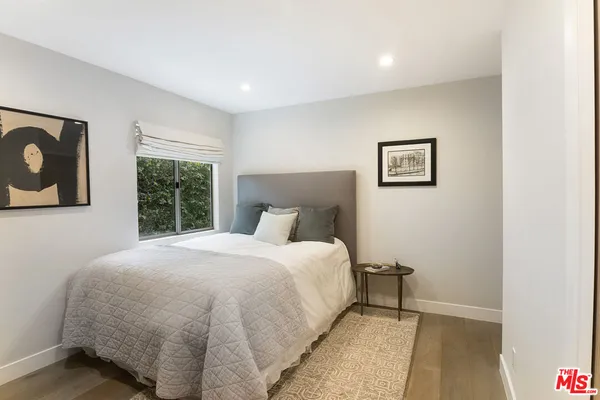 a large bed sitting in a bedroom next to a window