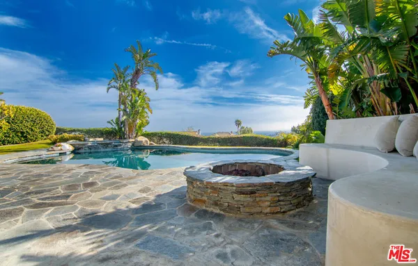 a view of swimming pool with outdoor seating and ocean view
