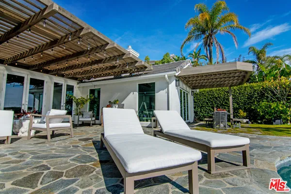 a view of a house with swimming pool and sitting area