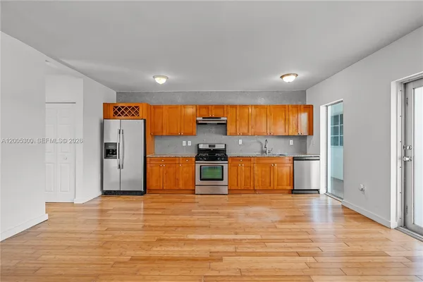 a kitchen with stainless steel appliances kitchen island granite countertop a refrigerator and a stove top oven