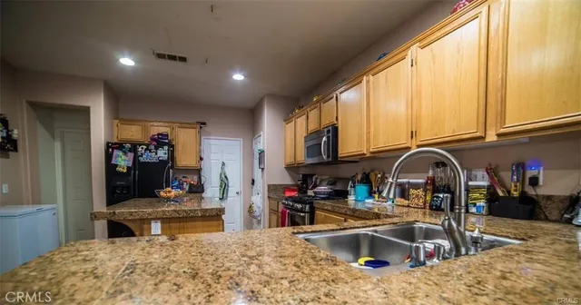a kitchen with stainless steel appliances kitchen island granite countertop a sink and cabinets