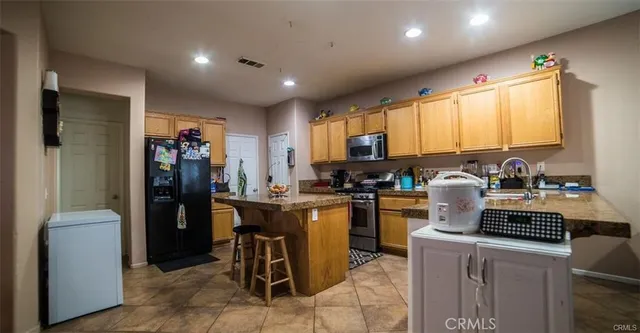 a kitchen with a refrigerator and a stove top oven