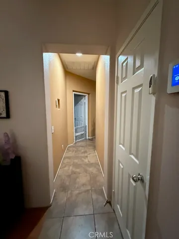 a view of a hallway with wooden floor and a bathroom