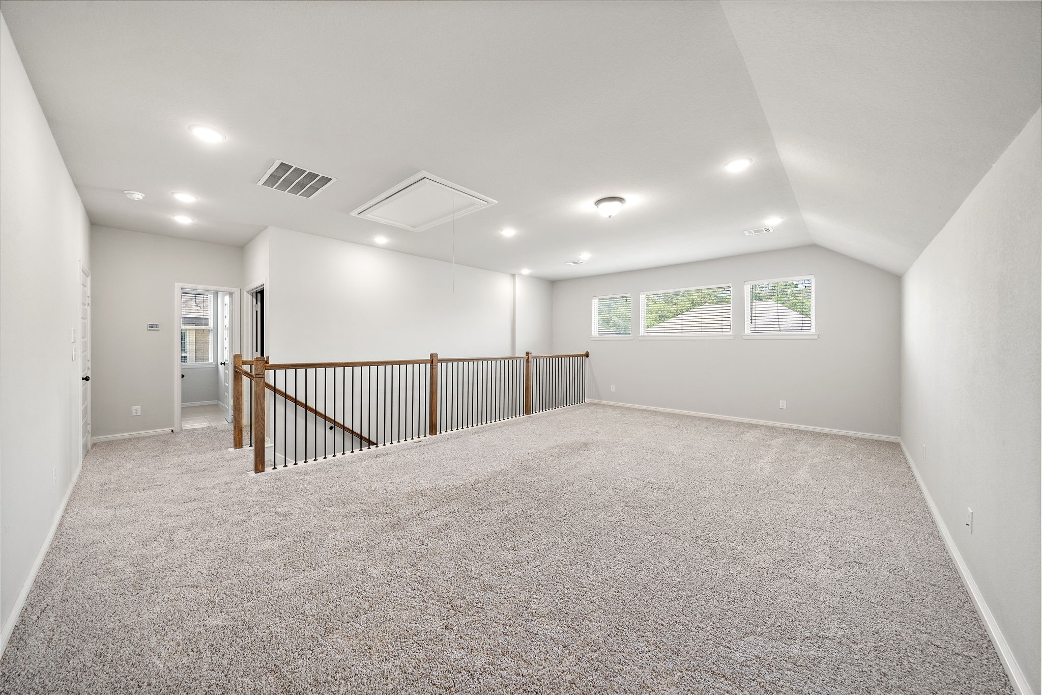 27924 Seger Bnd Trail Spring, TX 77386 - Photo 20 of 21 Carpeted upper-level, great for a game room features recessed lighting and a railing overlooking the lower level. It has three windows for natural light and access to an adjacent room, ideal for a playroom or office.
