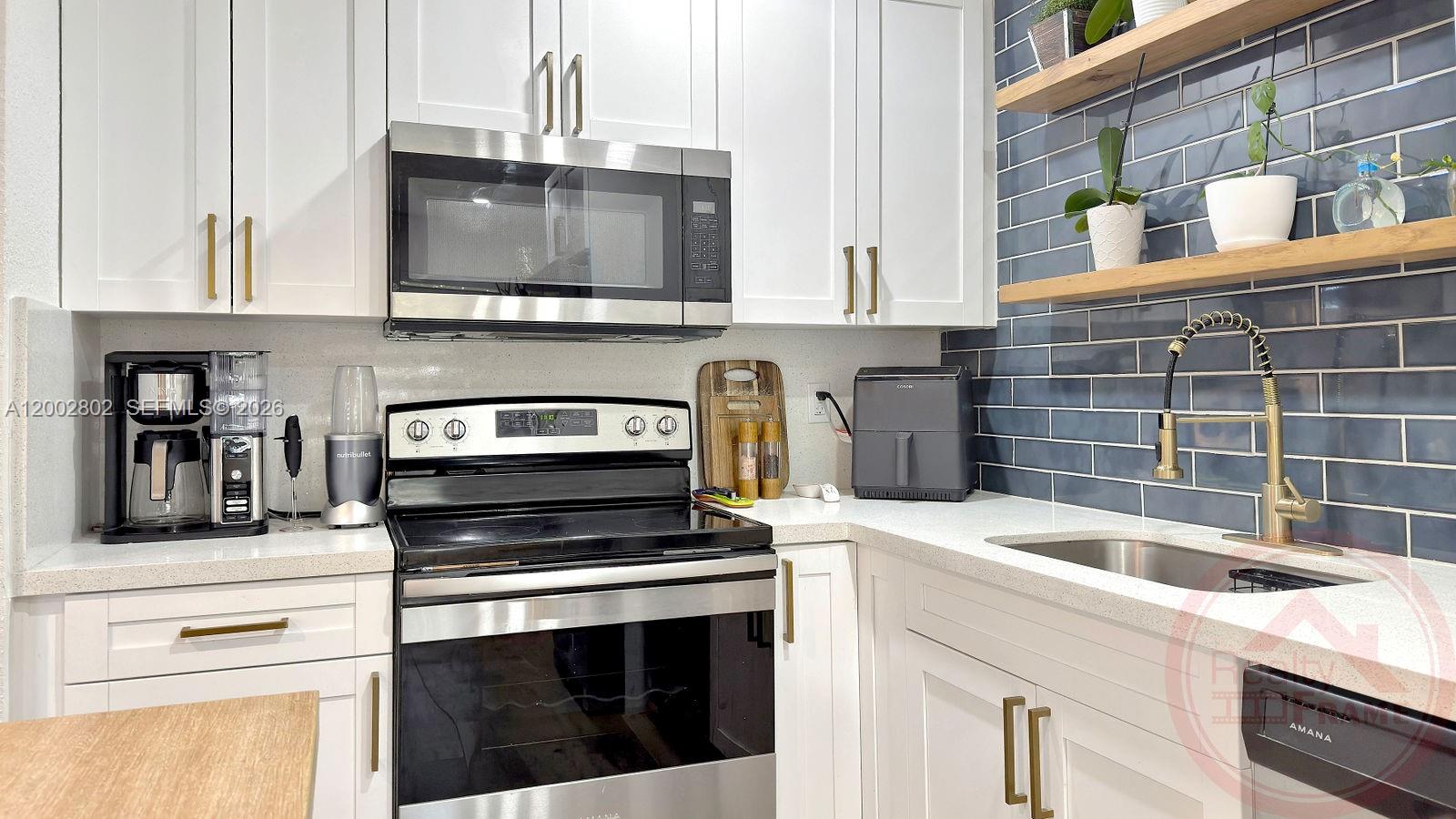 11240 Southwest 60th Terrace Miami, FL 33173 - Photo 15 of 19 a kitchen with granite countertop a stove top oven microwave and cabinets
