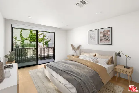a bedroom with a large bed and a balcony